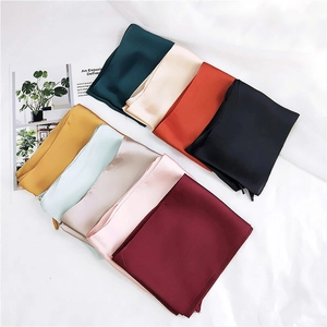 Close-up of colorful silk scarves in various elegant shades with smooth satin texture