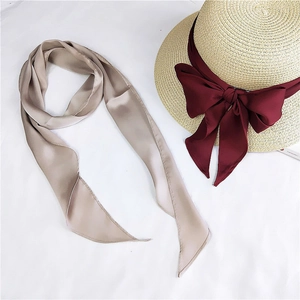 Detail of elegant champagne satin neck scarf with silky texture and stitched edges