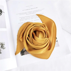 Artistic rose-fold detail of a mustard yellow silk scarf with soft texture and drape