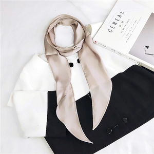 Detail of champagne satin skinny scarf showing premium texture and elegant pointed ends