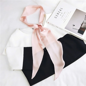 Close-up of pink satin silk scarf styled with a white shirt and black trousers