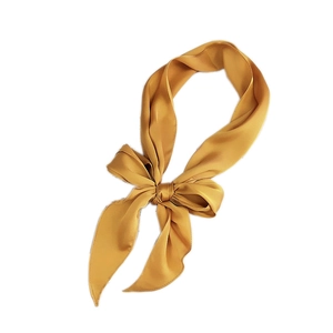 Fashionable mustard yellow satin neck scarf tied in a silk ribbon bow on white background