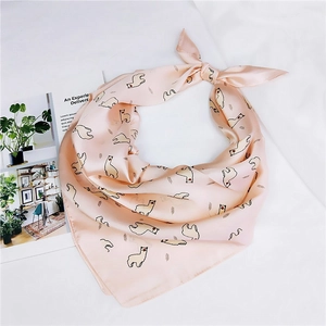 Gros plan d'un foulard en satin rose avec motif alpaga sur fond de tissu doux