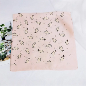 Détail d'un foulard en soie rose avec motifs alpaga et coutures fines sur fond blanc