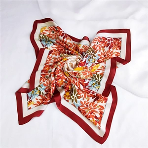 Carré de soie avec motifs floraux et bordure rouge sur fond de tissu blanc doux