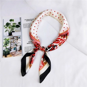 Détail d'un carré de soie avec pois rouges et imprimé floral sur un magazine décoratif