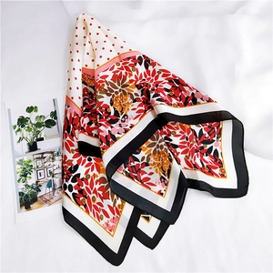Détail d'un foulard en soie à fleurs et pois sur un fond en tissu blanc doux