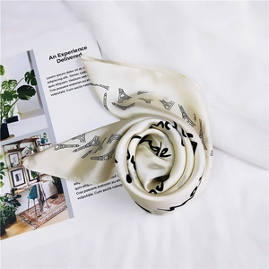 Detail of soft silk-like scarf with Eiffel Tower prints and elegant script handwriting