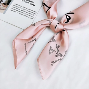 Close-up of pink silk scarf with Eiffel Tower print tied in an elegant knot detail