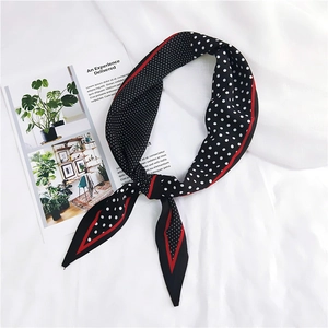 Polka dot silk scarf detail showing classic black and white pattern with red edges