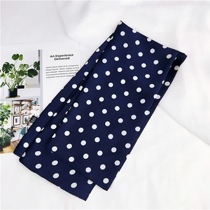 Sciarpa di seta blu scuro a pois bianchi su elegante sfondo bianco strutturato