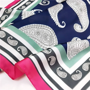 Détail d'un foulard en satin de soie avec motif paisley et bordures contrastées