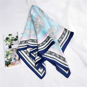 Détail du foulard carré bleu clair à motif cachemire avec texture satinée et rayures