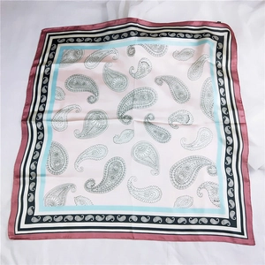 Détail du carré en soie à motif paisley avec bordures contrastées bordeaux et bleues