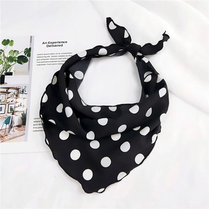 Close-up of black and white polka dot triangle silk scarf with soft drape texture