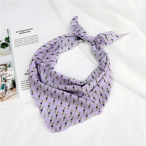 Close-up of lavender triangular silk scarf with green dotted print on white fabric