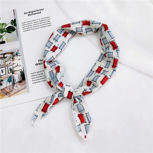 Detail shot of a geometric plaid silk neck scarf with red and blue patterns