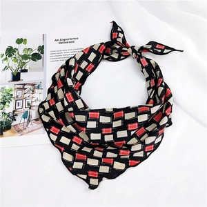 Close-up of geometric square print silk scarf with red and beige blocks and wavy edges