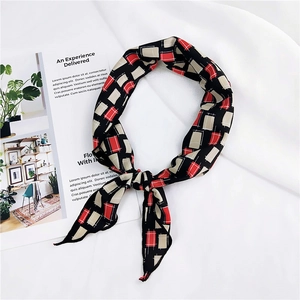 Detail of red and black geometric plaid pattern scarf on white textured fabric