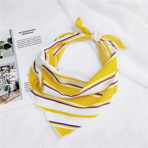 Close-up of yellow and white striped silk scarf with fine rolled edges on white fabric