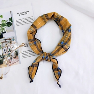 Detail of ginger yellow plaid silk scarf shown with glasses and art magazine