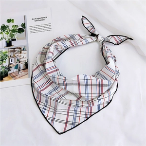 Detail of red and blue checkered silk scarf on white fabric with minimalist magazine