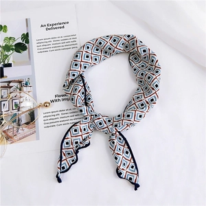 Detail of a geometric print satin scarf with navy and red patterns on white fabric