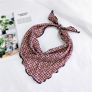 Detail of vintage geometric silk scarf with contrast wavy edges on white soft fabric