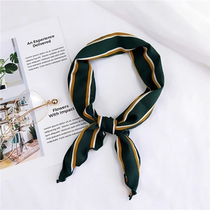 Detail of dark green striped silk scarf styled as a headband with vintage accessories