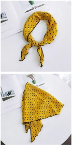 Detail of a bright yellow silk scarf with black and white geometric cube patterns