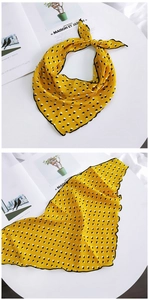 Detail of yellow geometric pattern silk scarf with elegant black wavy stitched edges
