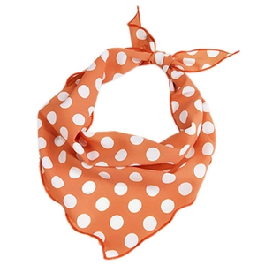 Orange silk neck scarf with white polka dot pattern tied in a stylish ring shape
