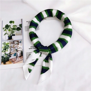 Detail of silk-like neck scarf with artistic green and navy blue brushstroke stripes