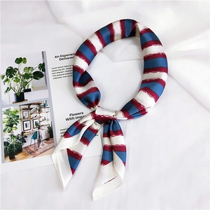 Close-up of red and blue striped silk scarf with soft drape on white fabric