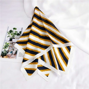 Detailed view of yellow and navy blue striped silk scarf with artistic brush textures