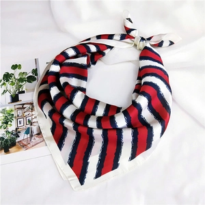 Detail of red and navy striped silk scarf with hand-painted edges on white fabric