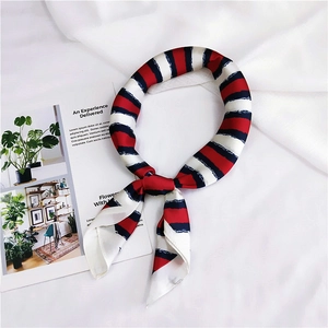 Detailed view of red, white, and navy striped silk scarf with elegant satin finish
