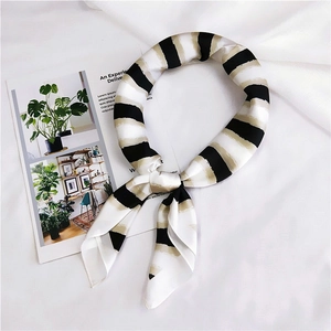 Detail of a silky tri-color striped narrow scarf with satin finish and pointed ends