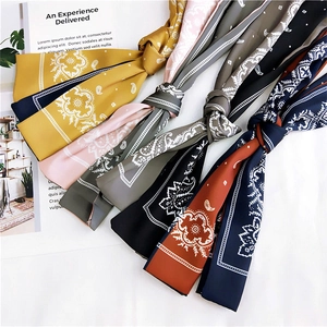 Multiple paisley satin scarves in yellow, pink, and navy for hair or neck styling