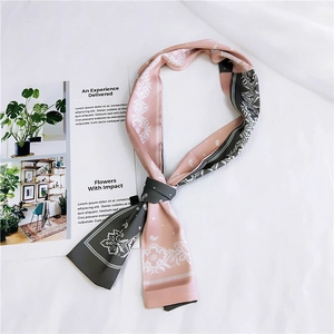 Detail of pink and grey paisley silk scarf styled naturally on white fabric background