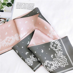 Detailed view of dual-color satin ribbon scarf with paisley pattern and floral border
