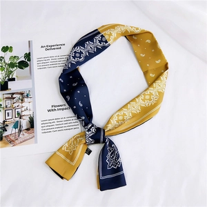 Detail of navy and mustard yellow paisley silk twilly scarf with elegant knotting