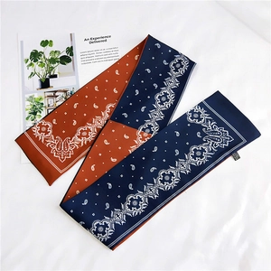 Detailed flat lay of paisley silk scarves in caramel orange and navy blue colors