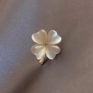 Broche trèfle exquise en or champagne avec pétales d'opale sur fond de satin luxueux