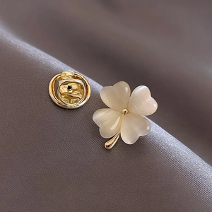 Broche trèfle à quatre feuilles plaquée or avec opales sur tissu en soie gris foncé