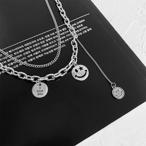 Collana multistrato in acciaio al titanio con ciondoli smiley e maglie di catena cubana