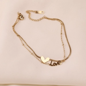 Detail of double-layer golden stainless steel anklet with heart and Love pendants
