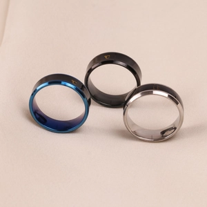 Close-up of smart temperature sensing rings in blue, black, and silver stainless steel