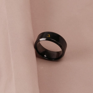 Close-up of a black temperature-sensitive ring with a gold Celsius symbol detail