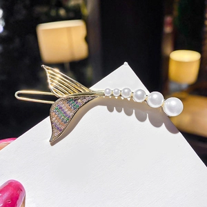 Detail of gold fishtail hair clip with gradient pearls and colorful rhinestones